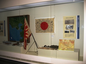 古い旗や写真がガラス越しに展示されている写真