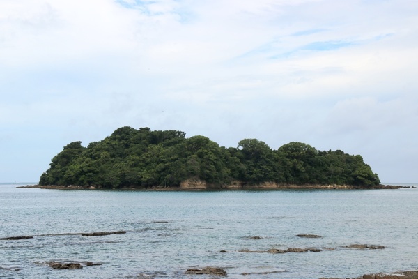 海の向こうに浮かぶ小島の写真