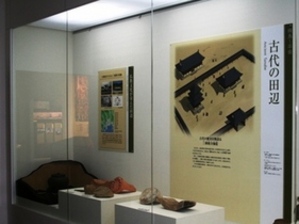 説明パネルと様々な形の出土品が並べられた展示の写真