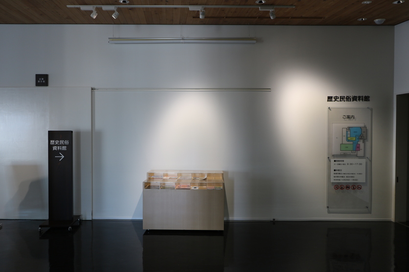 壁際にライトアップされた展示台が置かれている写真