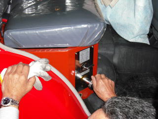 消防車の荷室で団員が可搬ポンプのホース接続をしている手元の写真