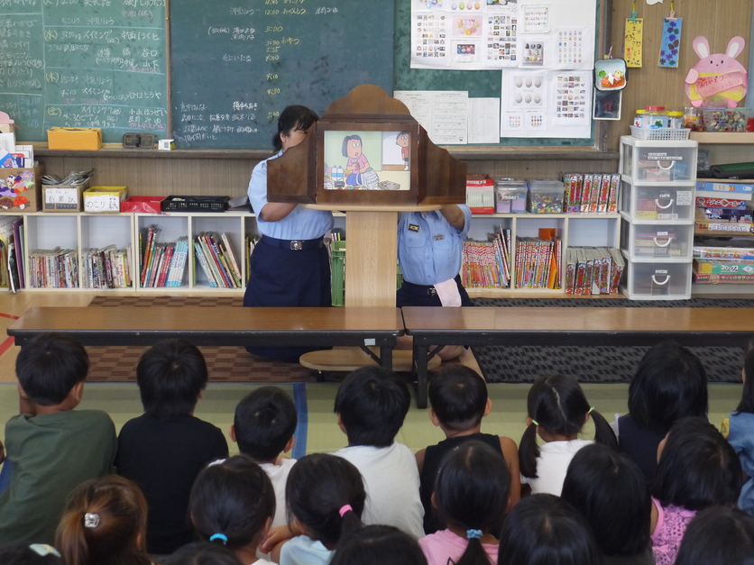 教室で職員が紙芝居を使って子どもたちに防災の話をしている様子の写真