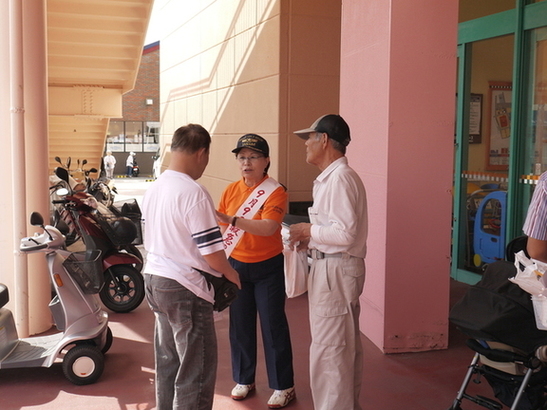 施設の通路で職員が来場者に案内を行っている様子の写真