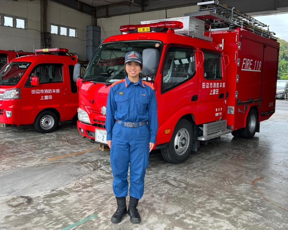 ドローン隊の職員がタンク車の前で直立するドローン隊職員