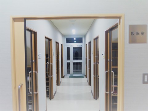 仮眠室の前の廊下で個室の扉が並んでいる様子を正面から写した写真