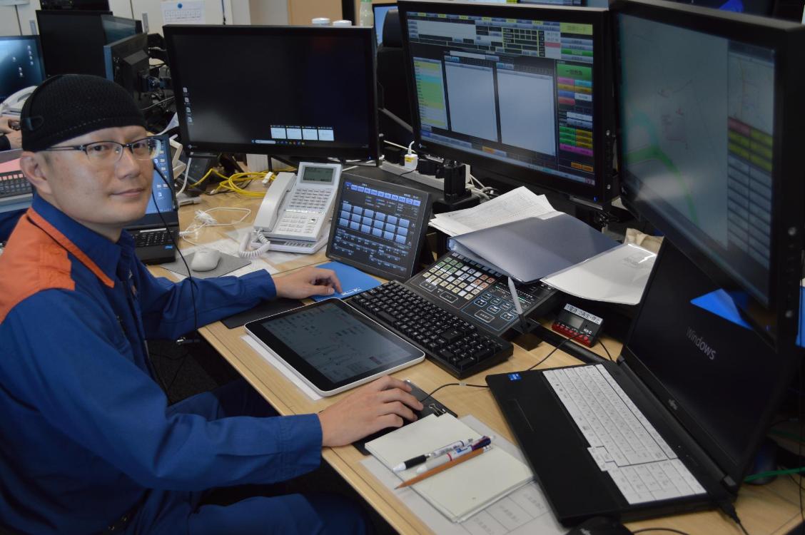 通信指令室でモニター画面を操作する指令センター員の写真