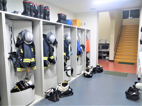 出動準備室で防火服や装備品が整然と並んでいる様子の写真