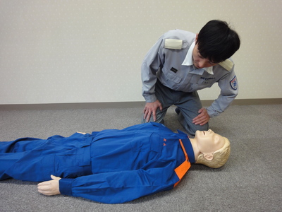 救助者が倒れている人の胸部や腹部を見て、呼吸があるか確認している画像