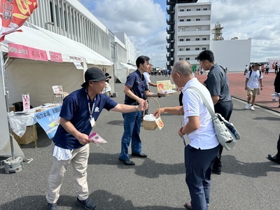 紺色のTシャツをきた男性2人が来場者に梅干しをサンプリングしている写真