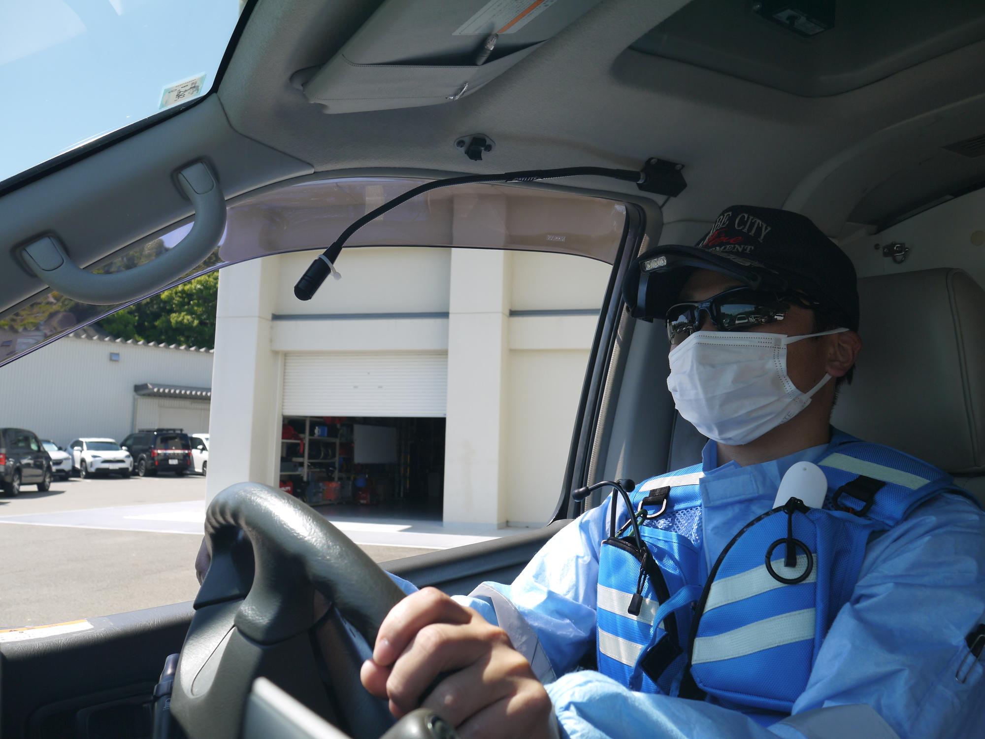 サングラスをかけて救急車を運転している隊員の画像