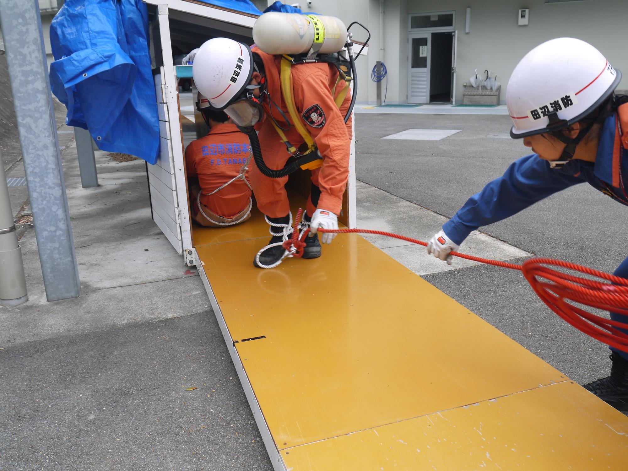 隊員が要救助者を引いてトンネル内を救出している画像