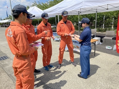 消防本部職員から個包装タイプの種ぬき梅干しを受け取る消防署員たちの写真
