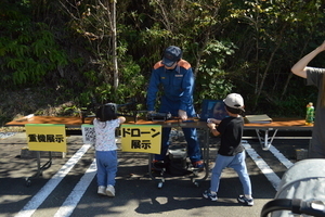 「ドローン展示」と示されたテーブルに子供2人が集まっている写真