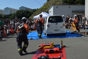 消防隊たちが車に向かって作業をしている写真