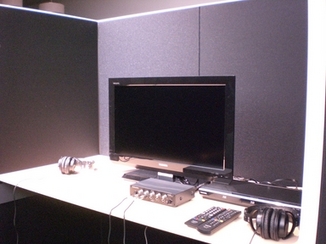 机の上にモニターとイヤホンが置かれているAVブースの写真