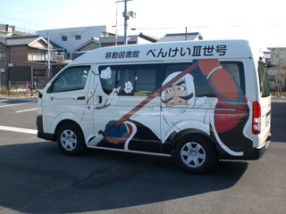 左上のフレームにべんけい3世号と書かれた白い大型の商用パンを横から撮影した写真