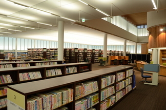 手前に背が低い本棚が並び、奥に背の高い本棚が並んでいる図書館内の写真