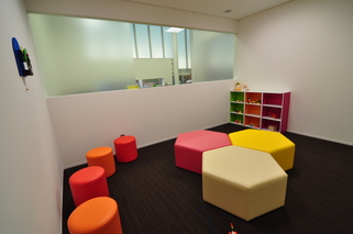 黒い絨毯の上にカラフルなソファが並んでいる部屋の写真