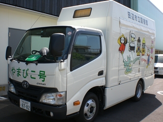 やまびこ号と正面のバンパーに書かれた白い2トントラックを正面斜め横写真