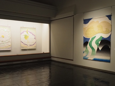三点のタピスリーを展示している美術館の展示室の風景写真