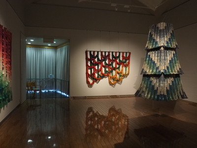 独創的な織作品を展示している美術館の展示室の風景写真