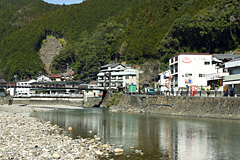 手前に大きな川が流れており、奥に温泉街が広がる場所の写真