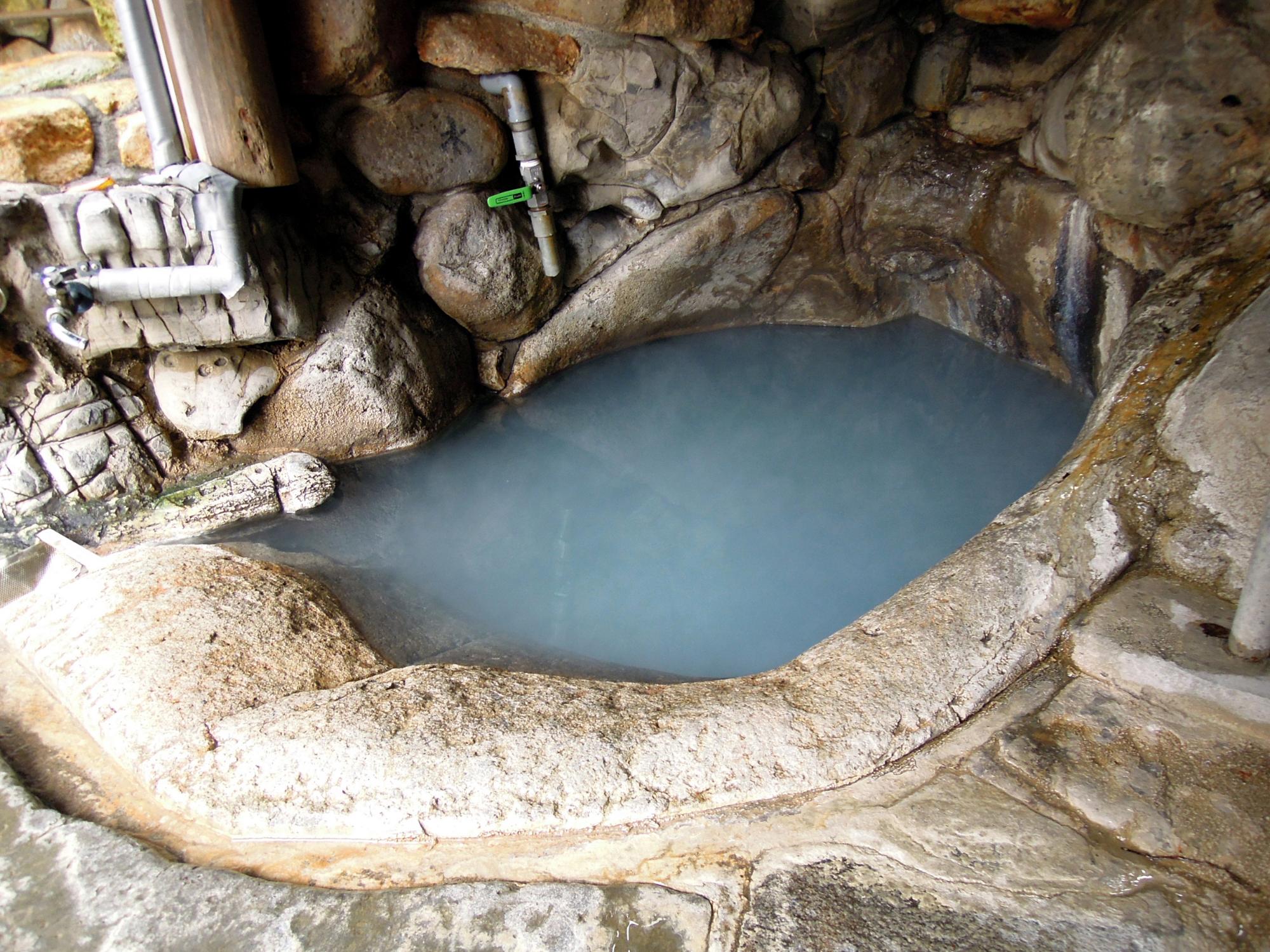 「つぼ湯」と書かれた木製の看板がある温泉施設の入り口正面からの写真