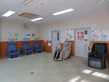 部屋の壁沿いに、いくつかの大きな椅子が背もたれを壁につけて置いてある写真