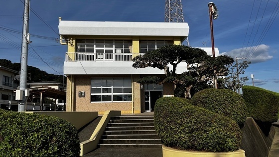 手前に玄関口につながる階段があり、奥に建物がある写真