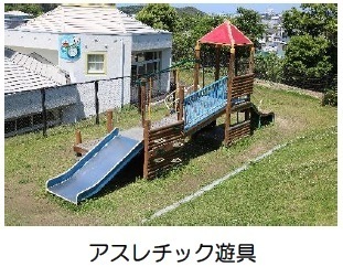 遠くに白い建物が見えて水色を用いたアスレチック遊具の写真