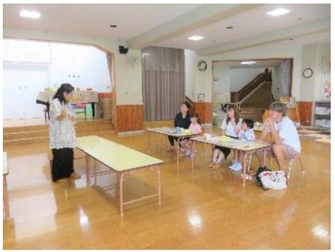 園児がお祭りについて話を聞いている写真