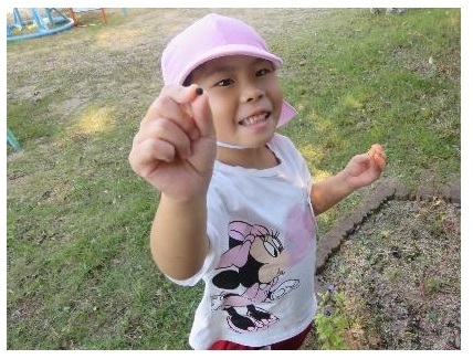 園児がアサガオの種を持っている写真