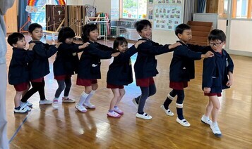 園児たちがジャンケン列車をして遊んでいる写真