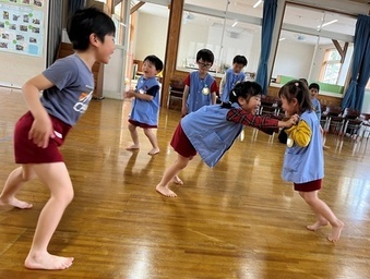 園児たちが相撲遊びに取り組んでいる写真