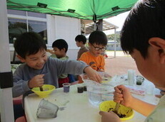 園児たちが様々なお花を使って色水作りに挑戦している写真