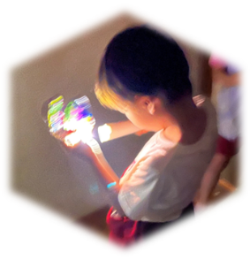 作った宝石を懐中電灯で光らせている写真