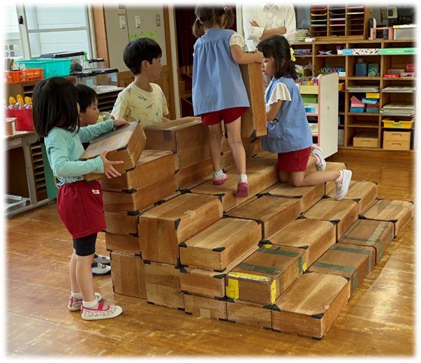 大型積み木の置き方を友達と相談している写真