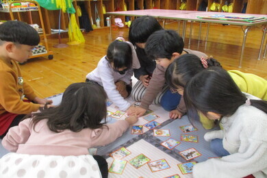 室内でかるたをしている七名の園児たちの写真