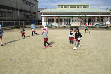 園舎の外の広場で園児たちが歩いている写真