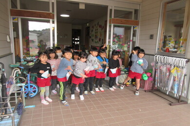 園舎の入口に園児たちが集まって豆まきをしている写真