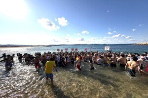 スーツを着た4人の男性が横一列に並んで立ち本を両手で持って開いている写真