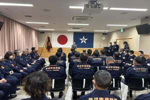 対談式にて、大勢の消防団員が椅子に座って参加している写真