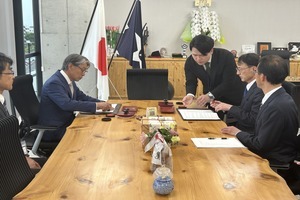 スーツを着た男性達が対面で座り、資料を確認しながら話し合いを行っている写真