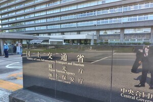 「国土交通省」の文字が刻まれた石碑のような看板があり、奥に建物がある写真