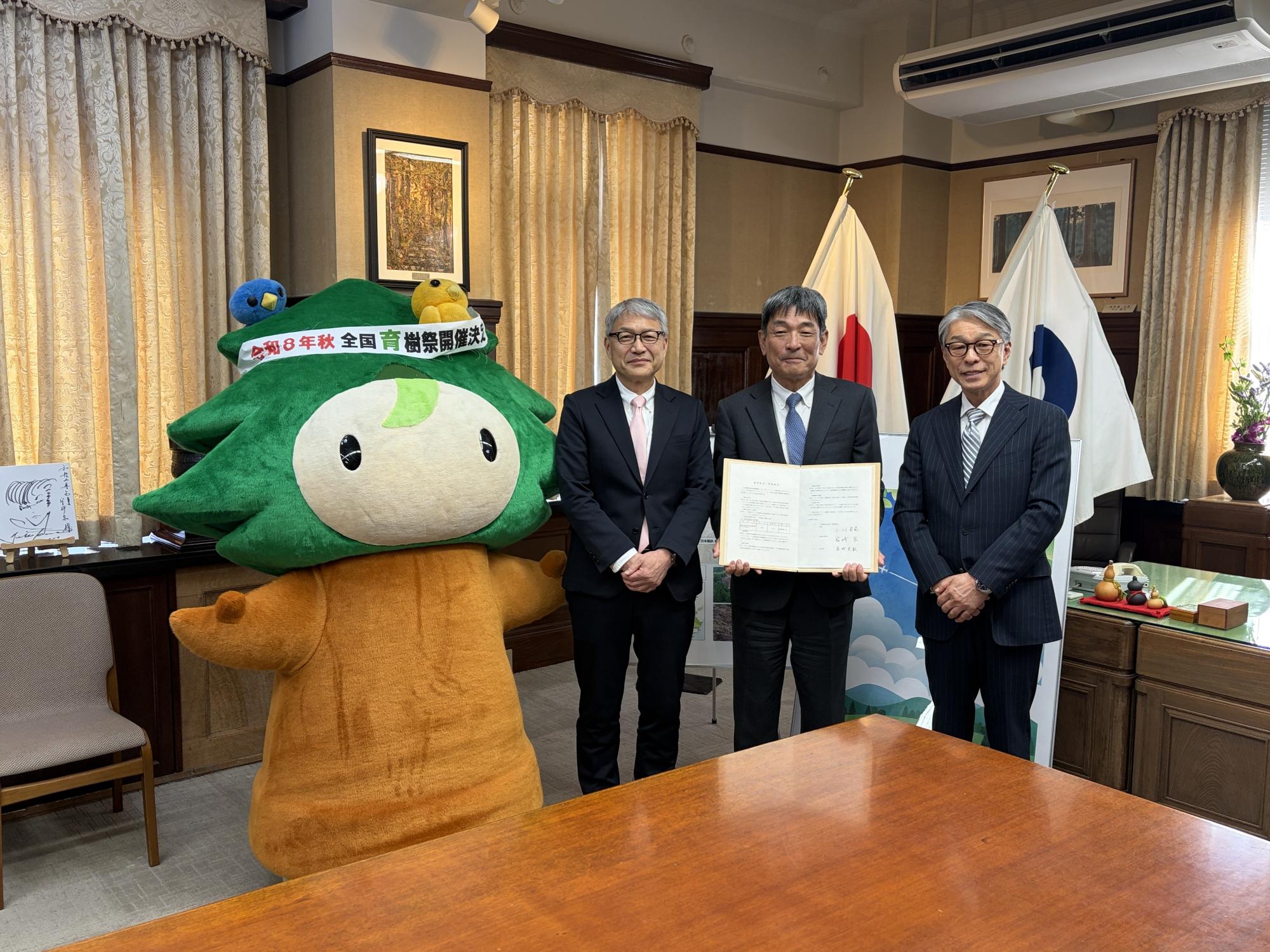企業の森調印式で、記念撮影を行う和歌山県知事と日本製鉄株式会社関西製鉄所代表者と市長の写真